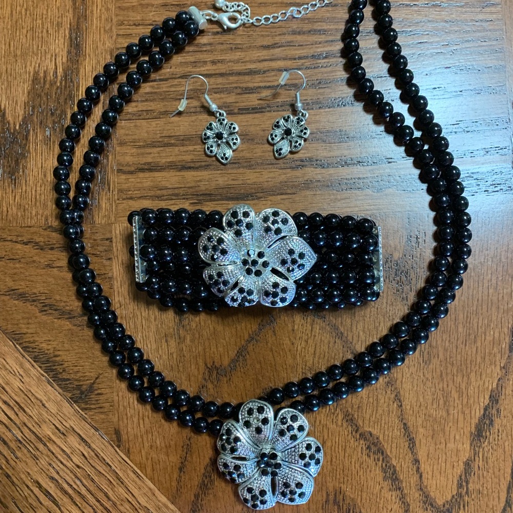 Black and silver necklace, bracelet, and earrings
